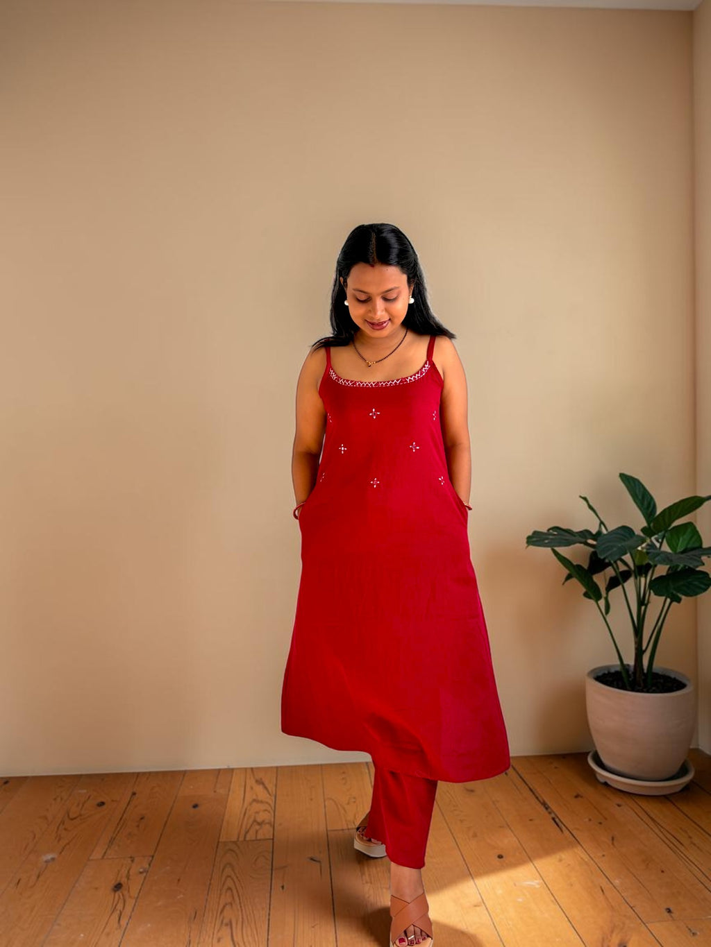 Vasanam red spaghetti strap kurta with white embroidery and matching slim-fit pants. A-line silhouette with pockets.